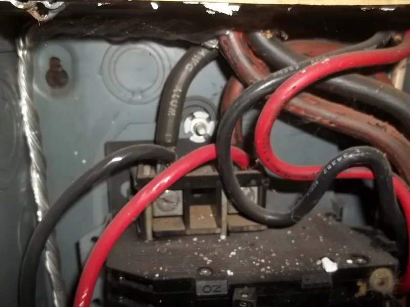 Conductors with melted, charred insulation inside an electrical panel