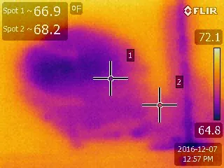 FLIR thermal image showing a cool moisture plume spreading across a ceiling