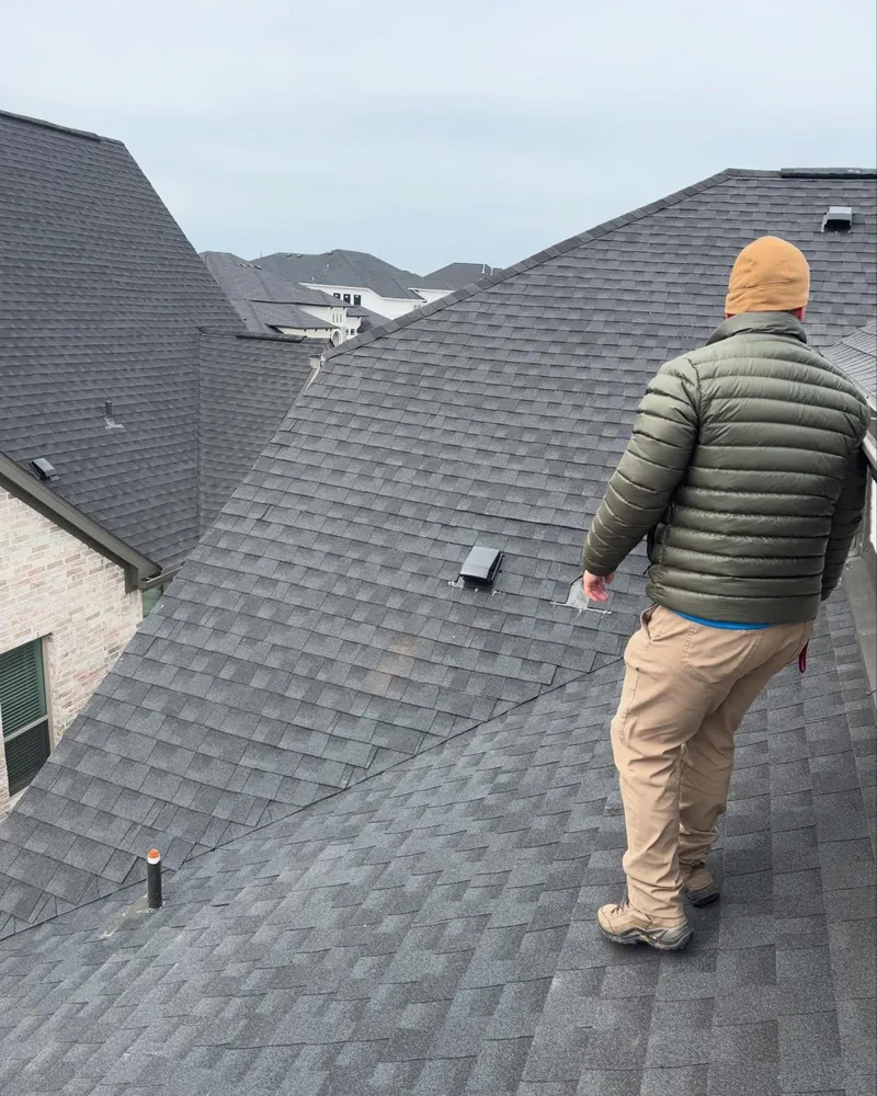 An A-Action inspector walking the roof of a newly built home in a Houston subdivision