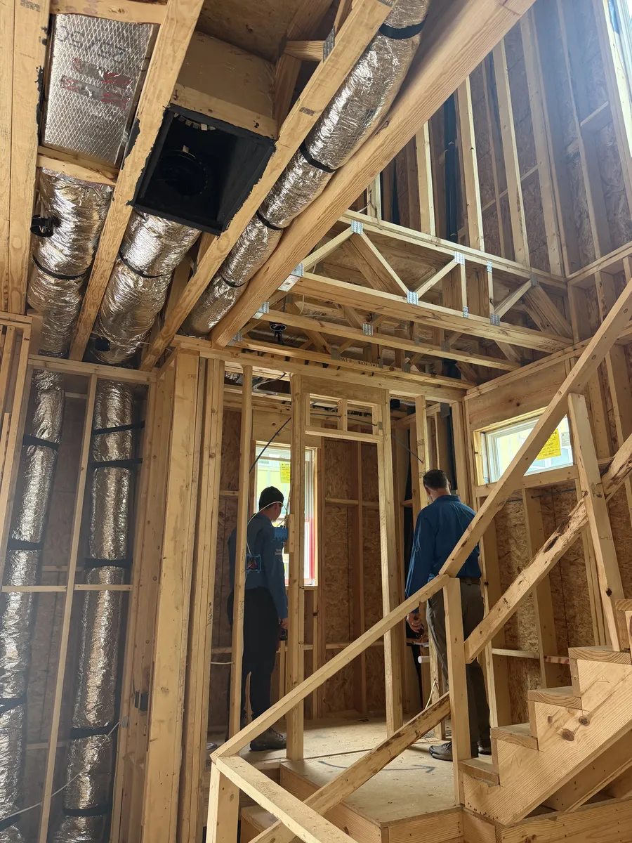 Two A-Action inspectors walking a framed house before drywall during a phase inspection