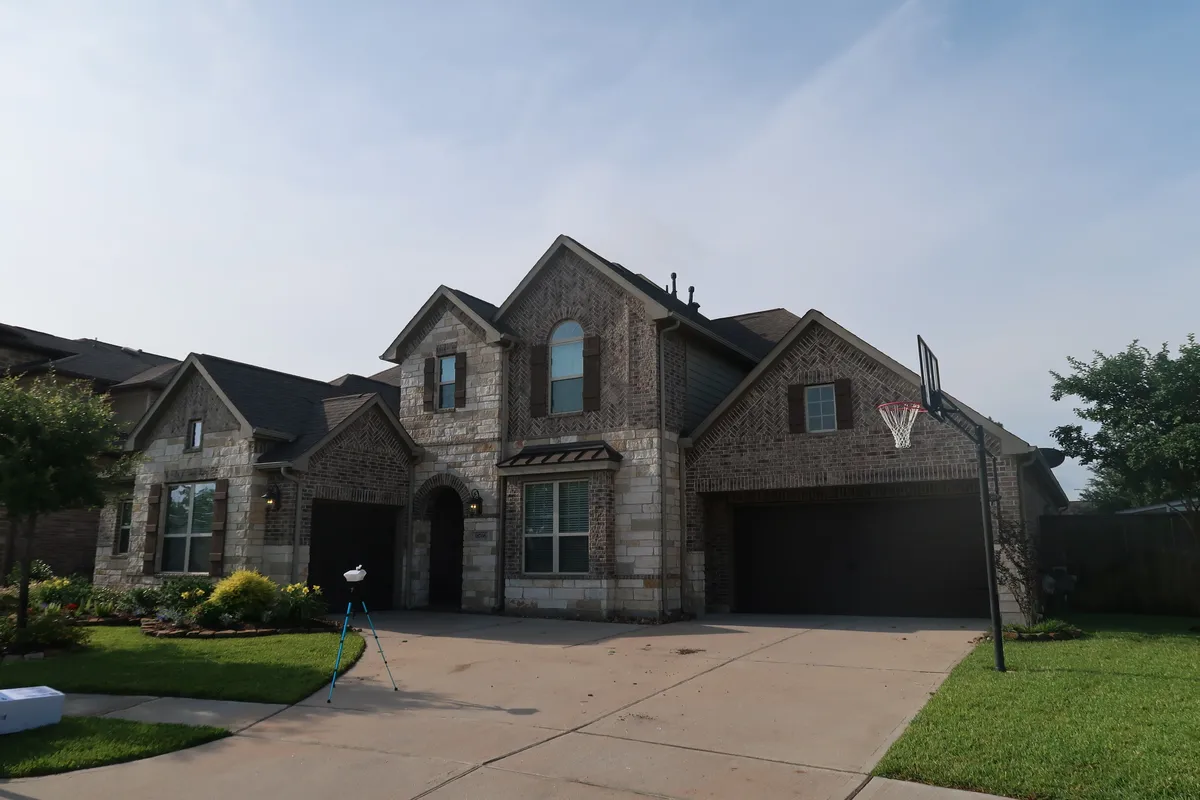 A newer stone-front Houston home with an inspection camera set up in the driveway